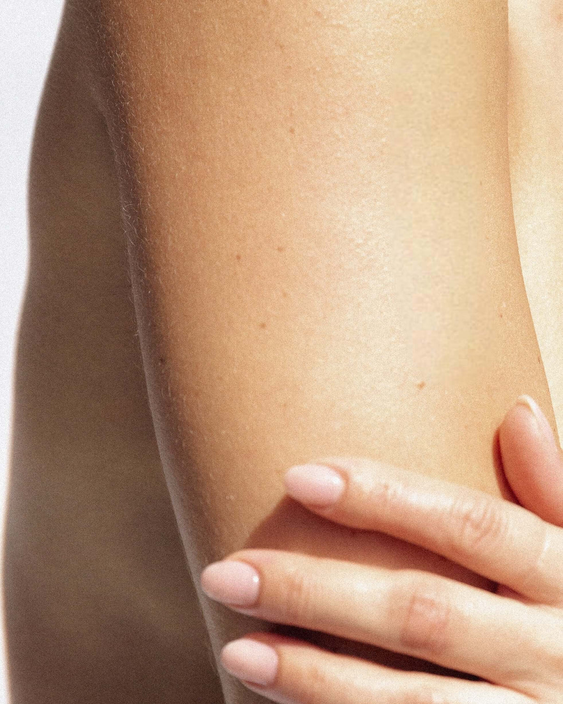 hand using exfoliating mitt in shower to remove dead skin