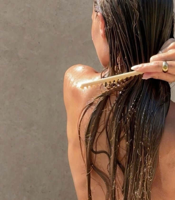 Woman brushing hair after shower with filtered water