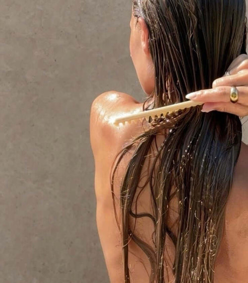 Woman brushing hair after shower with filtered water